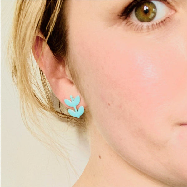 Model wearing enamel flower stud earrings